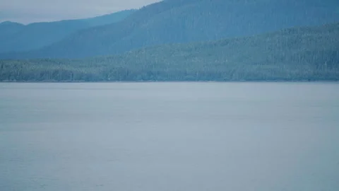 Humpback whale blowing in front of layered mountains Stock-Footage 348017747