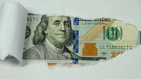 A hundred-dollar bill appears from under the white paper Stock Footage 75874099