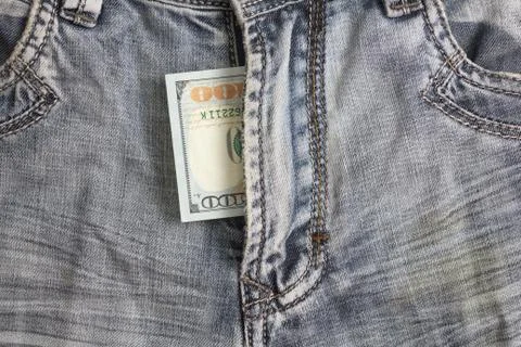 Hundred dollar bill inside  codpiece blue jeans Stock Photos