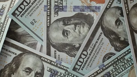 Hundred dollar bills arranged in an overlapping pattern on a flat surface. This Stock Footage 338297732