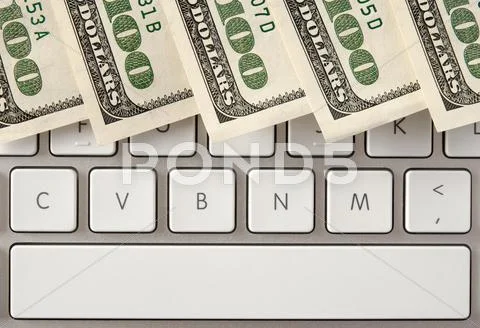 Hundred dollar bills on computer keyboard with spacebar Stock Photos