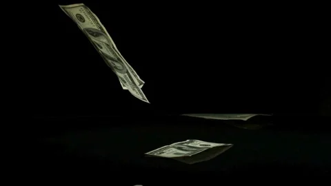 Hundred dollar bills fall onto dark surface Video stock 326753534