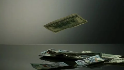 Hundred dollar bills fall on a dark reflective surface Video stock 327512969