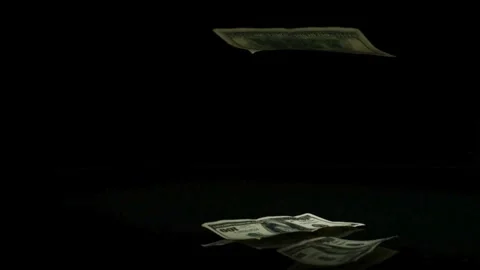 Hundred dollar bills falling and piling on black surface Stock Footage 327577955