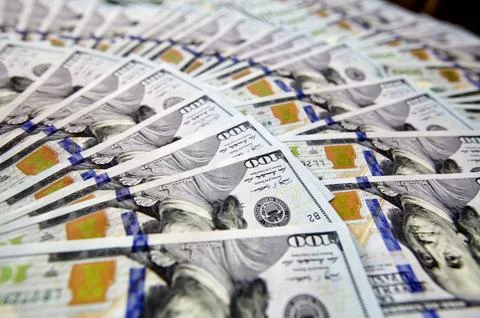 Hundred dollar bills spread in a fan shape on white background Stock Photos