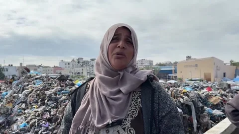Hundreds of displaced Palestinians forced to settle next to Gaza City landfill s Stock Footage 304750352
