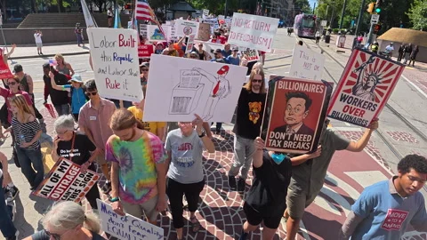 Hundreds march with signs at Workers Over Billionaires protest Stock Footage 317512541