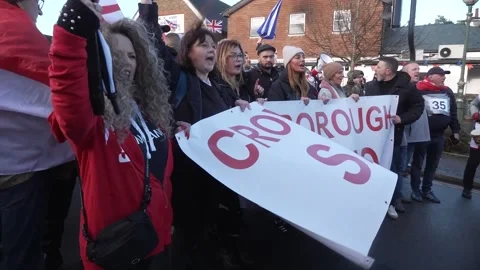 Hundreds march through Crowborough in protest against proposed migrant camp  Video stock 321646542