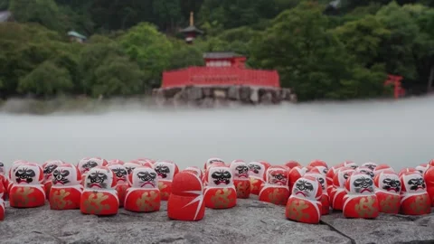 Hundreds of red Daruma dolls placed on stone platform at Katsuoji Temple in Stock Footage 345186734