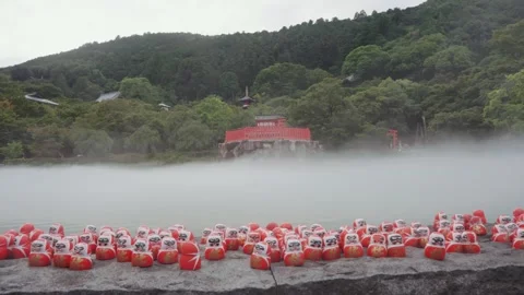 Hundreds of red Daruma dolls on stone platform at Katsuoji Temple in Osaka Stock Footage 345186169