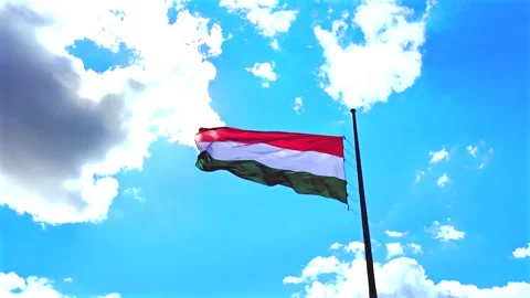 Hungarian Flag Waving Gracefully Against a Bright Blue Sky Stock Footage 346367098