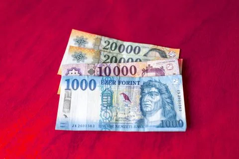 Hungarian forint bank notes displayed on a red surface Stock Photos