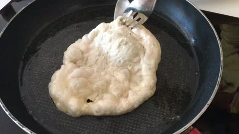 A Hungarian specialty, a deep fried flat bread made of potato-based dough Stock Footage 132585648
