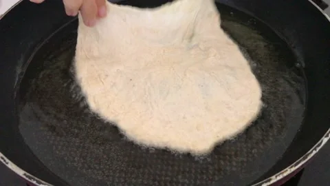 A Hungarian specialty, a deep fried flat bread made of potato-based dough Stock Footage 132585661