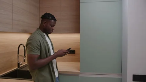 Hungry Black Man Opening Empty Fridge using Cell Phone. Frustrated African Stock Footage 257063463