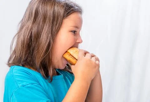 Hungry child bite burger Stock Photos