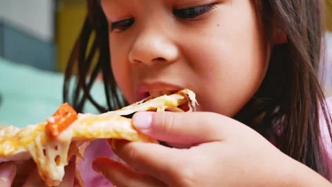 Hungry child taking a bite from pizza on a pizza party at home. Stock Footage 165714170