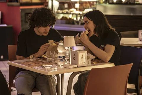  Hungry Couple Dining at Bar Table Masi, Italy 7 june 2023: Young man and ... Fotos Stock