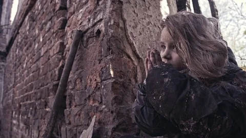 Hungry homeless children near the ruins. The child prays. Stock Footage