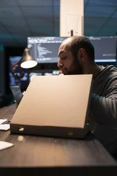 Hungry Male Coder Takes Dinner Break at Desk Stock Photos