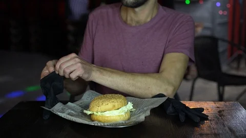 Hungry man in a bar eating a Burger. Stock Footage 106371453