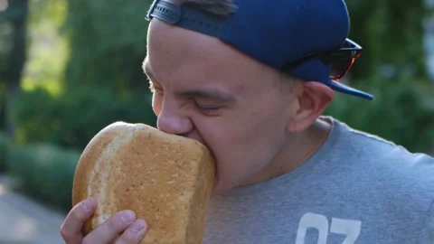 Hungry man eating bread holding a loaf in his hands Stock Footage 135877822