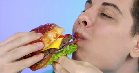 Hungry man eating fresh burger with sauce Stock Footage 166858732