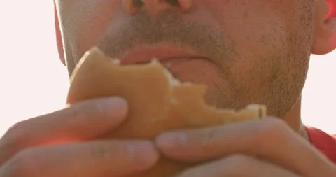Hungry man eats fresh hamburger on sunny day closeup Vidéo 160816925