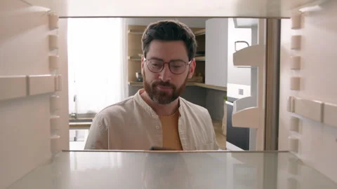 Hungry man guy open empty refrigerator poor crisis order food delivery with Stock Footage 244520236