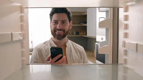 Hungry man guy open empty refrigerator poor crisis order food delivery with Stock Photos