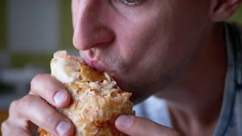 Hungry Man Takes a Bite of Delicious and Crispy Shawarma Close-up. Slow Motion. 動画素材 140479323