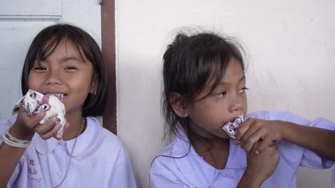 Hungry Primary School Students Sitting on the Floor and Joyfully Drinking Milk Stock Footage 156750147