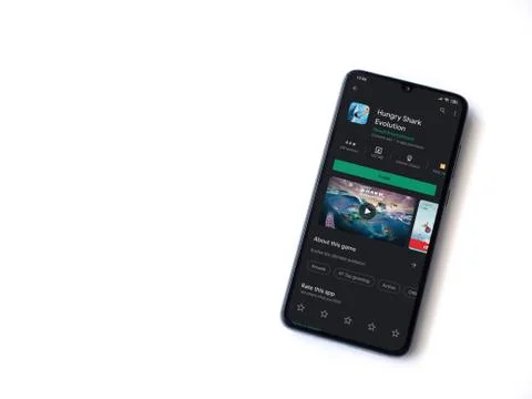Hungry Shark Evolution app play store page on the display of a black mobile s Stock Photos