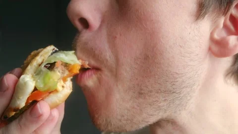 Hungry young man eating a fresh hamburger Stock Footage 337830547