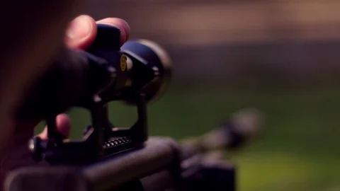 Hunter adjusting snipe rifle scope Stock Footage 73835805