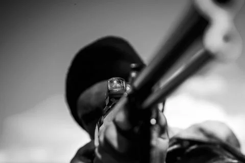 Hunter aiming rifle in forest. Hunter with shotgun gun on hunt. Autumn hunting Stock Photos