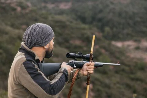 Hunter aiming with rifle in the mountain during hunting season Stock Photos