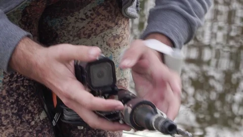 The hunter attaches an action camera to a speargun. Spearfishing. Stock Footage 101685329