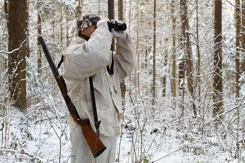 Hunter with binoculars in the winter forest Stock Photos