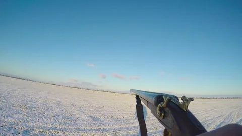 Hunter carries a gun in front of him in the winter field 스톡 동영상 83472116