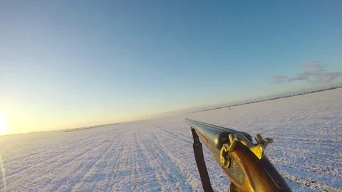 Hunter carries a gun in front of him in the winter field Stock-Footage 83472805