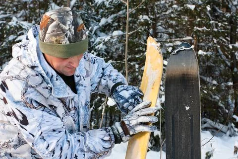 Hunter cleans skis in the forest Stock Photos