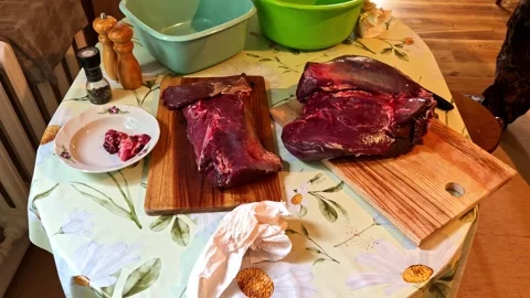 Hunter cutting fresh roe deer venison on a wooden cutting board in the kitchen Stock-Footage 347707342