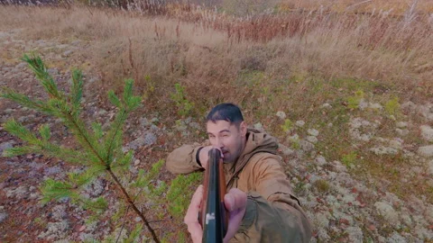 A hunter enthusiastically tracks down a target in a tree and shoots it. Stock Footage 318871411