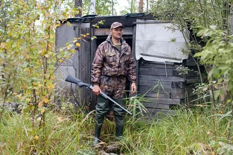 Hunter at the forest hut Stock Photos