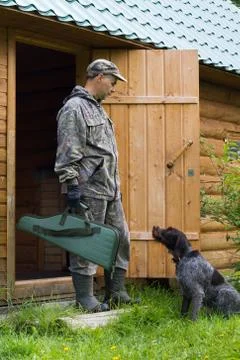 A hunter with a gun case in his hand and a dog Stock Photos