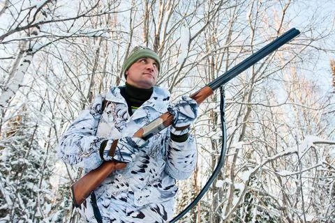 Hunter with a gun in hand in winter Stock Photos