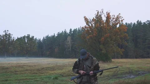 A hunter with a gun tracks down the prey. Aim a hunting rifle. Beautiful autumn Video stock 142526873