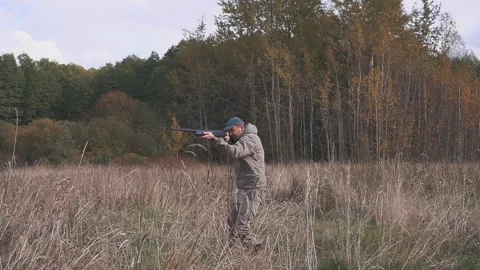 A hunter with a gun tracks down the prey. Aim a hunting rifle. The concept of Stock Footage 142527704