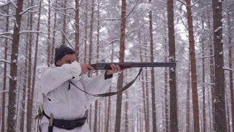 A hunter with a gun tracks down the prey. Aim a hunting rifle. Winter forest Stock Footage 150865376